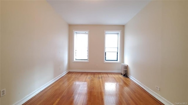 unfurnished room featuring light wood-type flooring and radiator