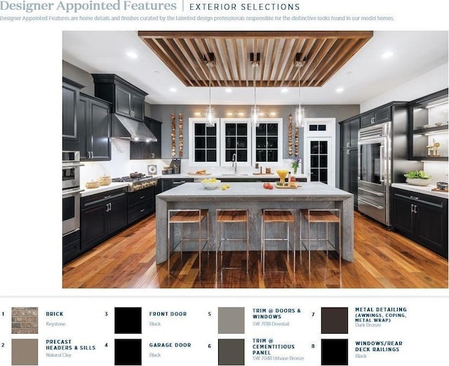 kitchen with a kitchen bar, appliances with stainless steel finishes, a kitchen island, and hardwood / wood-style flooring