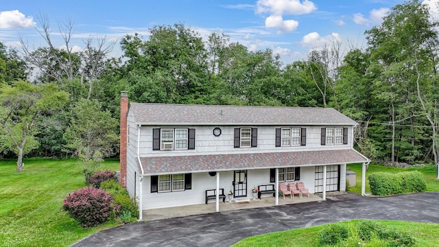 138 Reinhardt Rd, Middletown, NY 10940 - view of front of house featuring covered porch, asphalt driveway, a chimney, a front lawn, and a shingled roof