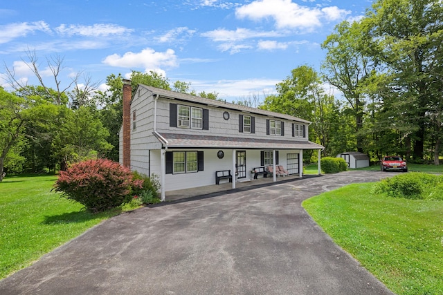 138 Reinhardt Rd, Middletown, NY 10940 - view of front facade with a porch, a storage unit, a chimney, a front lawn, and driveway