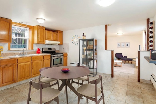 kitchen with light tile patterned floors, gas stove, and sink