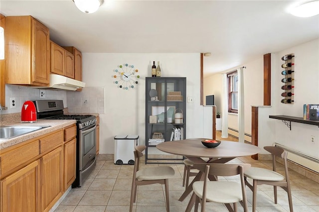 kitchen featuring exhaust hood, sink, gas range, decorative backsplash, and light tile patterned floors