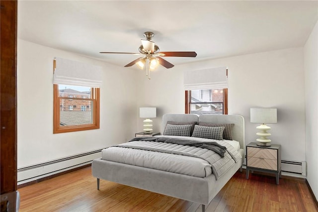 bedroom featuring hardwood / wood-style floors, a baseboard radiator, and ceiling fan