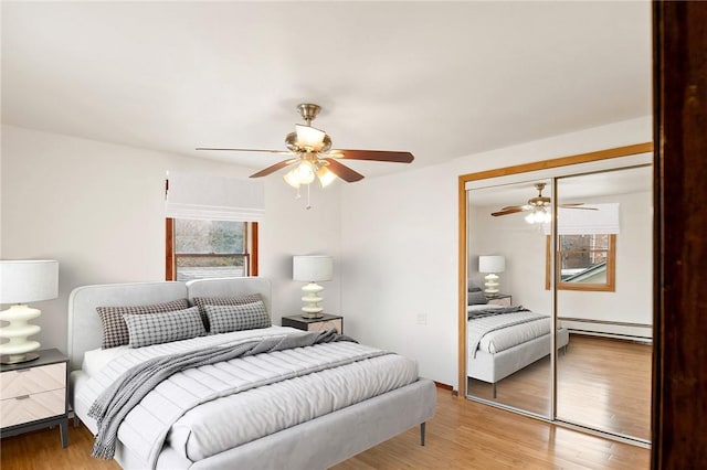 bedroom with ceiling fan, a closet, a baseboard radiator, and light hardwood / wood-style flooring