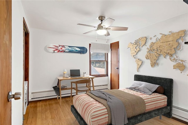 bedroom with baseboard heating, ceiling fan, and light wood-type flooring