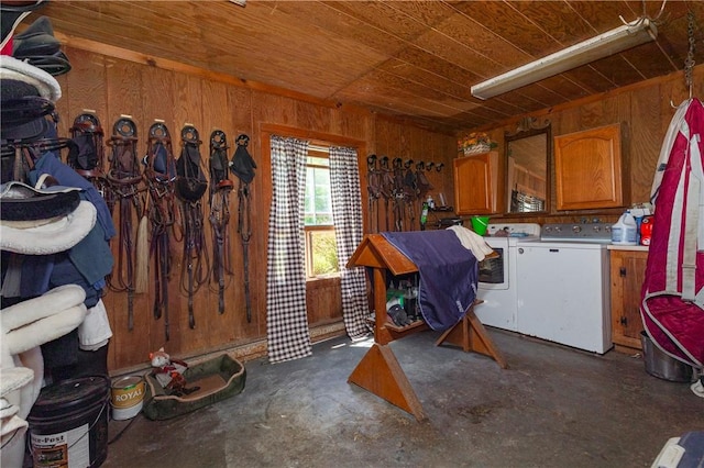 interior space featuring cabinets, washing machine and dryer, and wooden walls