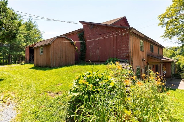 view of property exterior with a lawn and a shed