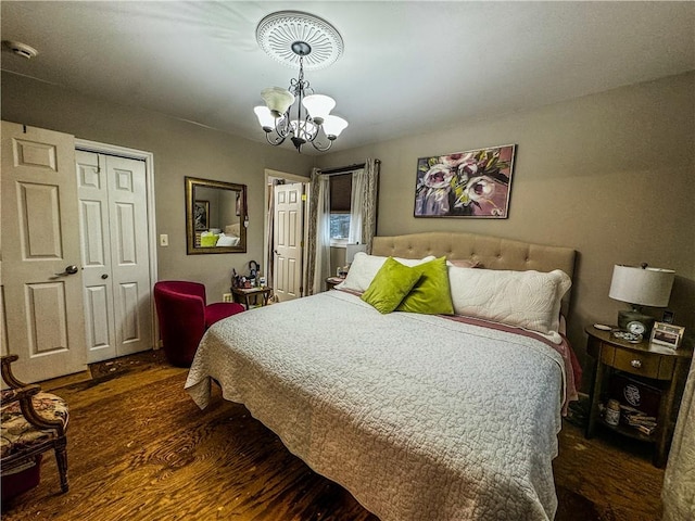 bedroom with a chandelier, a closet, and dark wood-type flooring