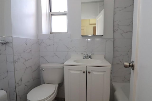 bathroom with vanity, tile walls, and toilet