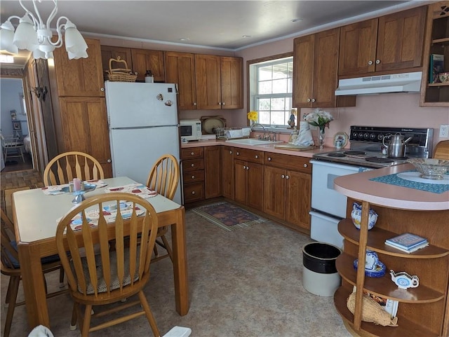 kitchen featuring sink, a chandelier, and white appliances