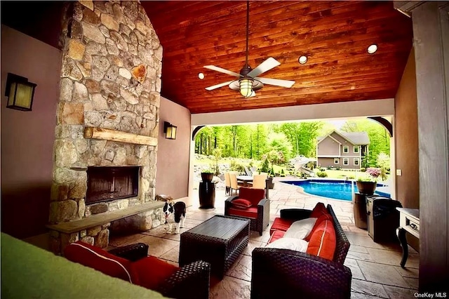 view of patio / terrace with an outdoor living space with a fireplace and ceiling fan