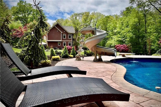 view of swimming pool featuring pool water feature, a patio, and a water slide