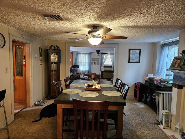 carpeted dining space featuring ceiling fan and a textured ceiling