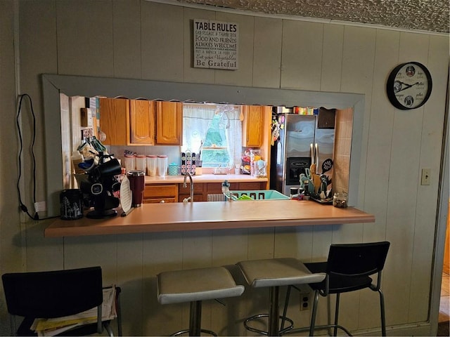 kitchen with a kitchen bar and stainless steel fridge