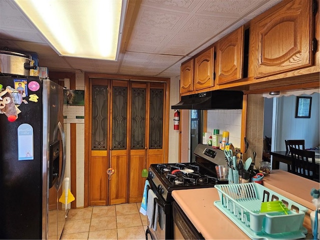 kitchen featuring light tile patterned flooring and appliances with stainless steel finishes