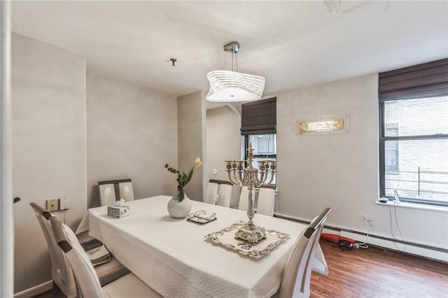 dining space with dark wood-type flooring and a baseboard heating unit