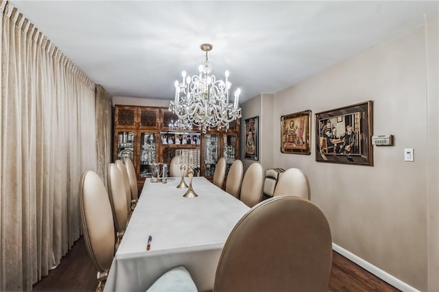 dining area with dark hardwood / wood-style floors and a notable chandelier