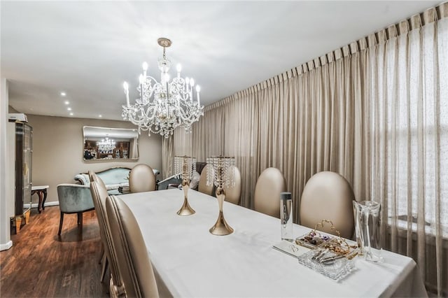 dining area with hardwood / wood-style floors and an inviting chandelier