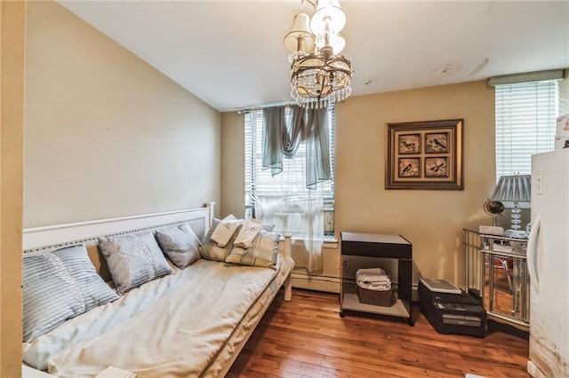 interior space featuring baseboard heating, dark hardwood / wood-style floors, an inviting chandelier, and a wealth of natural light