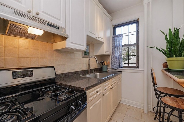 kitchen with white cabinets, sink, decorative backsplash, gas range oven, and light tile patterned flooring