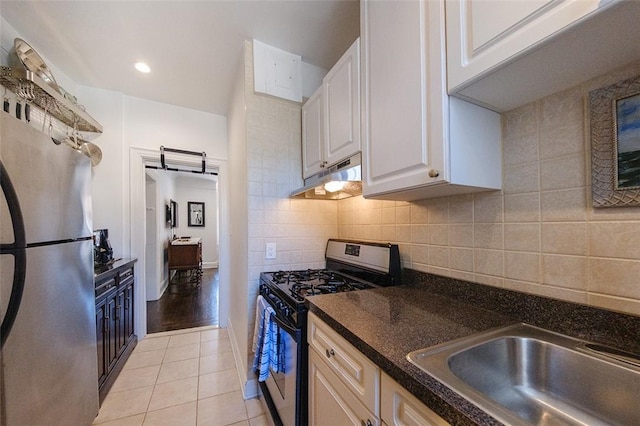 kitchen with stainless steel refrigerator, sink, gas range oven, white cabinets, and light wood-type flooring