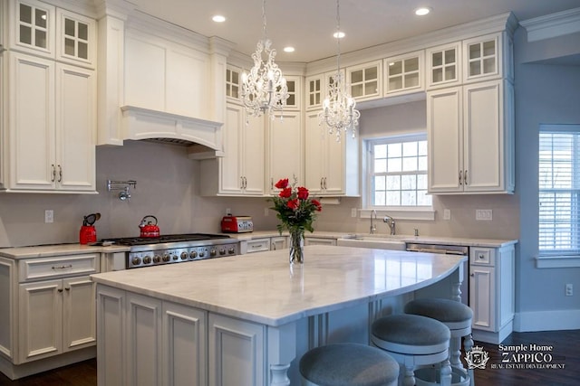 kitchen featuring white cabinetry, dishwasher, a kitchen island, and an inviting chandelier