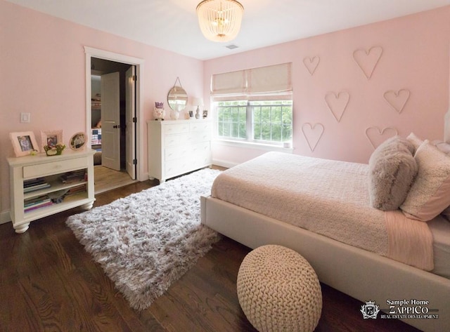 bedroom with a notable chandelier and hardwood / wood-style flooring