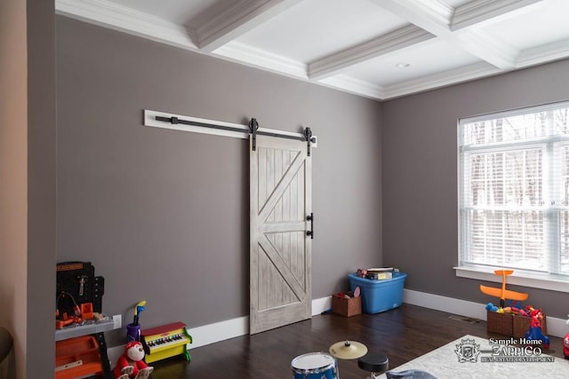 game room featuring beam ceiling, a barn door, a healthy amount of sunlight, and dark hardwood / wood-style floors