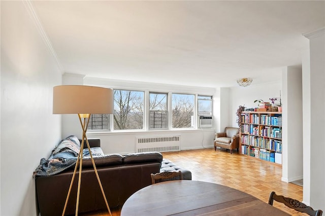 living room featuring radiator, crown molding, and light parquet floors