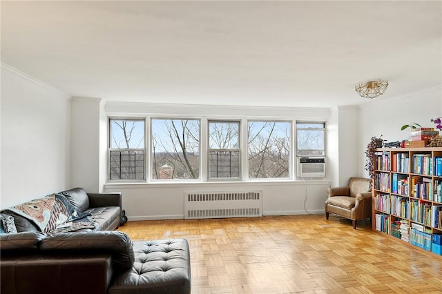 living area with radiator, light parquet flooring, cooling unit, and ornamental molding