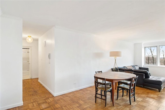 dining space featuring light parquet flooring and ornamental molding