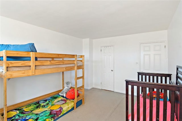 bedroom featuring carpet and a crib