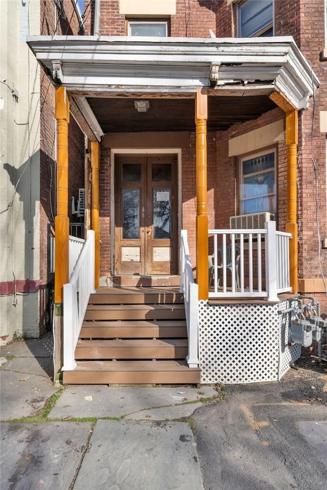 property entrance with covered porch and french doors