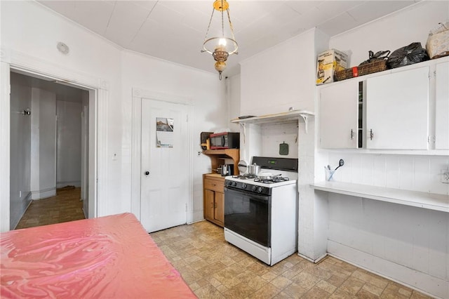 kitchen featuring white cabinets, crown molding, white gas range oven, decorative backsplash, and decorative light fixtures