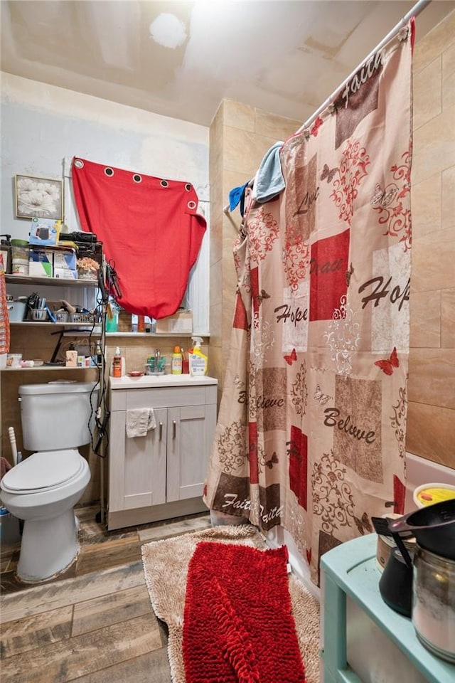 bathroom featuring hardwood / wood-style floors, toilet, curtained shower, and sink