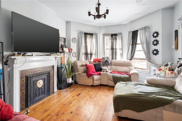 living room featuring hardwood / wood-style flooring, a fireplace, and a chandelier