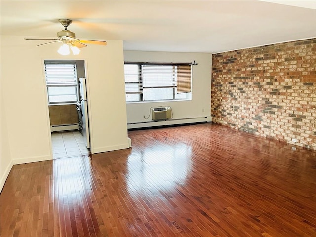 unfurnished living room with hardwood / wood-style flooring, ceiling fan, baseboard heating, and brick wall