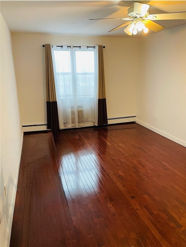 spare room featuring baseboard heating, dark wood-type flooring, and ceiling fan