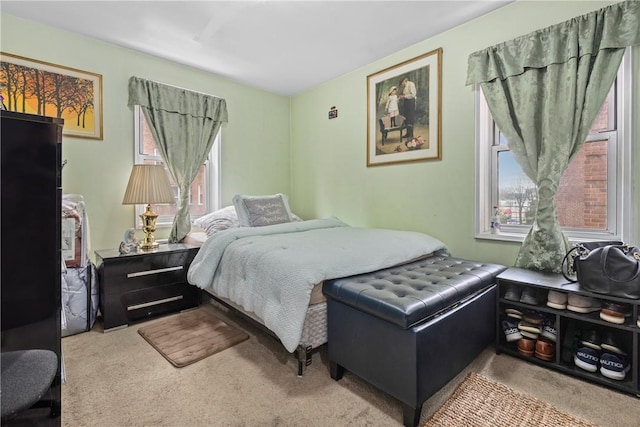 bedroom featuring light carpet and multiple windows