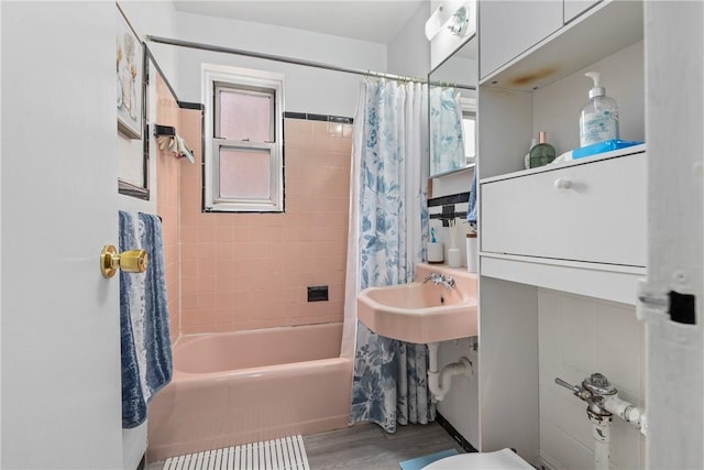 bathroom featuring a wealth of natural light, shower / tub combo with curtain, and hardwood / wood-style flooring