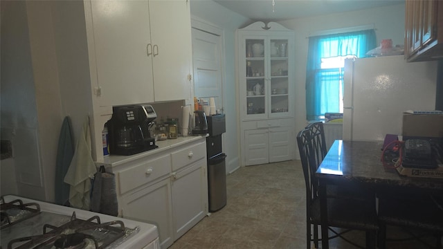 kitchen with white refrigerator and white cabinets