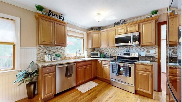 59 Ludingtonville Rd, Holmes, NY 12531 - kitchen featuring stainless steel appliances, a sink, light wood-type flooring, backsplash, and wainscoting