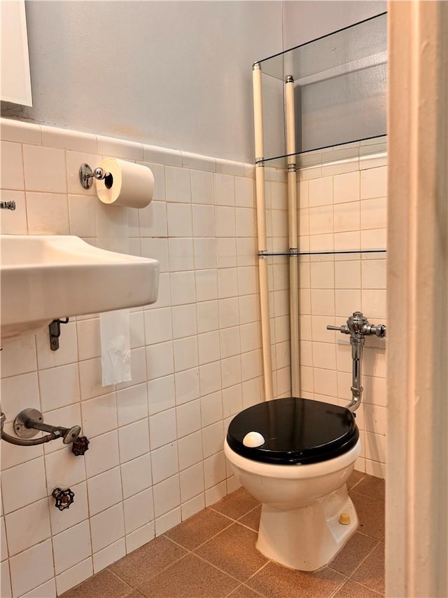 bathroom with tile patterned floors, tile walls, and toilet