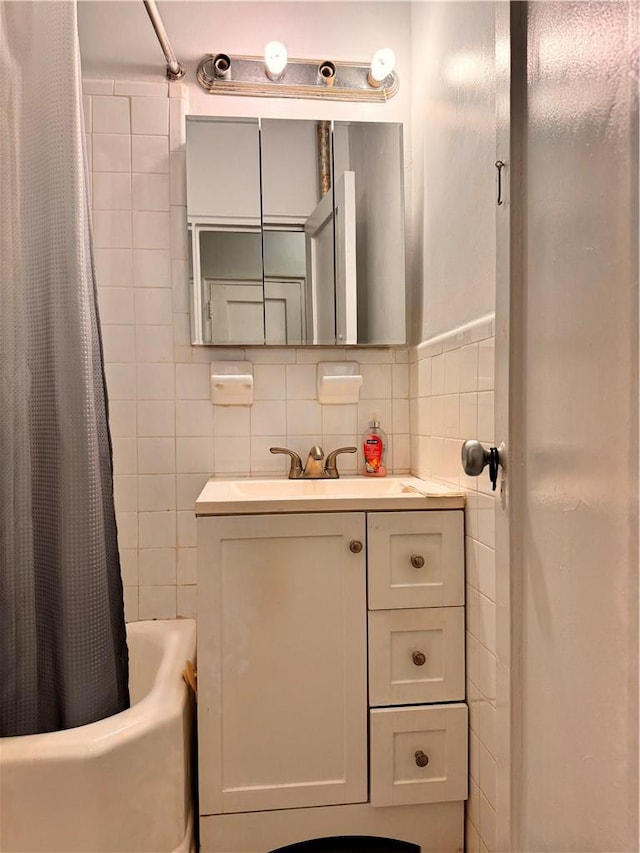 bathroom featuring shower / bath combo, vanity, tasteful backsplash, and tile walls