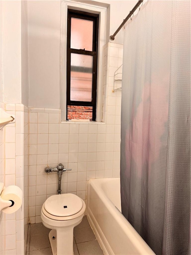 bathroom featuring tile patterned flooring, shower / bathtub combination with curtain, tile walls, and toilet