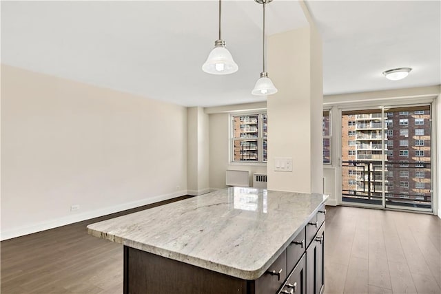 kitchen with dark brown cabinetry, light stone countertops, radiator heating unit, decorative light fixtures, and hardwood / wood-style flooring