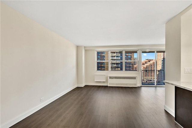 unfurnished living room featuring radiator heating unit and dark hardwood / wood-style floors