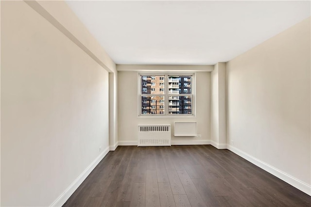 unfurnished room with radiator and dark hardwood / wood-style floors