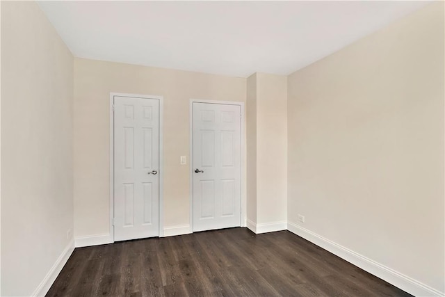 unfurnished bedroom with dark wood-type flooring