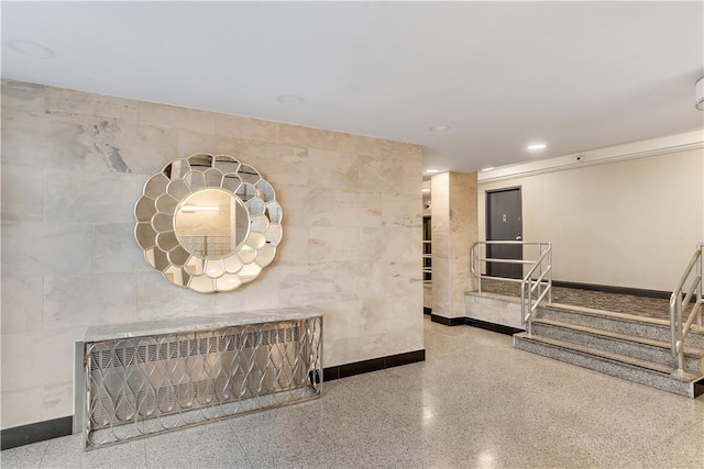 hallway featuring radiator and tile walls